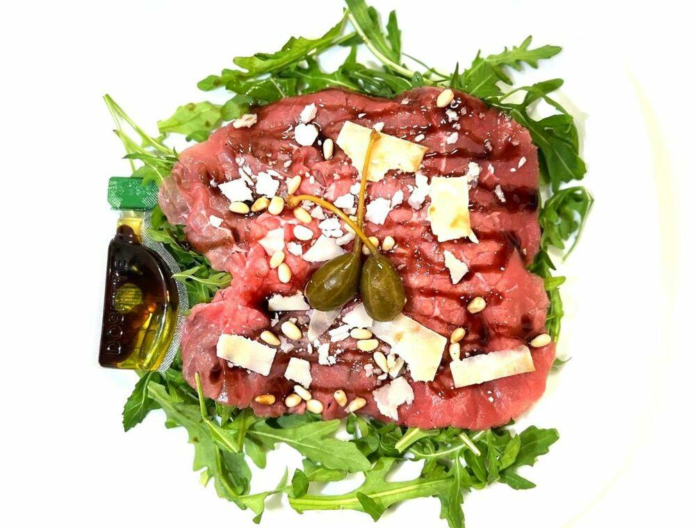 Rundscarpaccio met rucola, pijnboompitjes, olijfolie, balsamico en Parmezaanse kaas