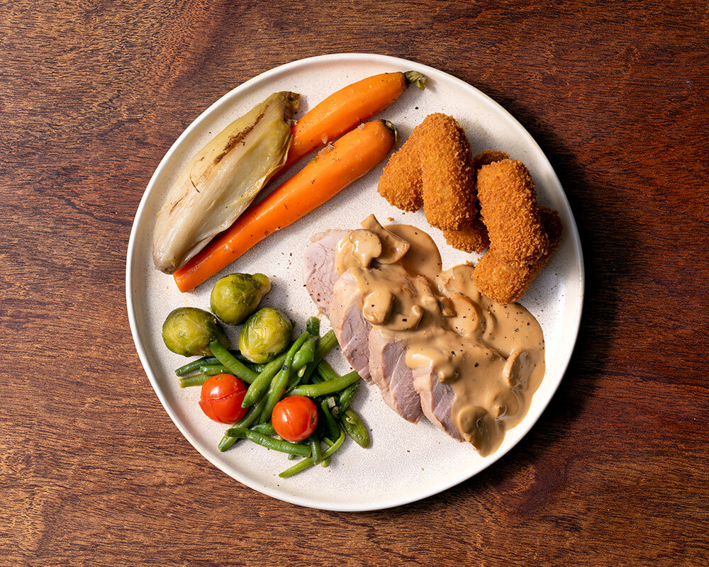 Varkenshaasje in champignonsaus met warme groentemengeling en verse kroketjes